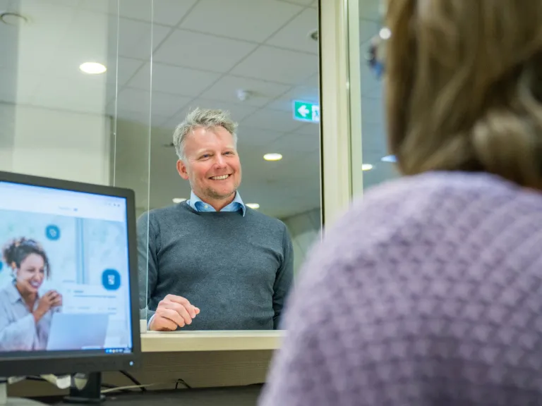 Doktersassistent helpt patiënt aan balie