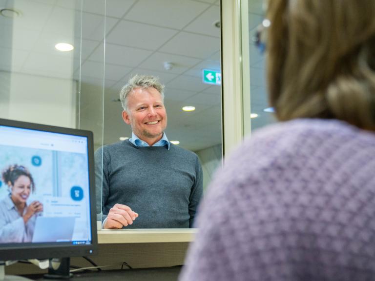 Doktersassistent helpt patiënt aan balie