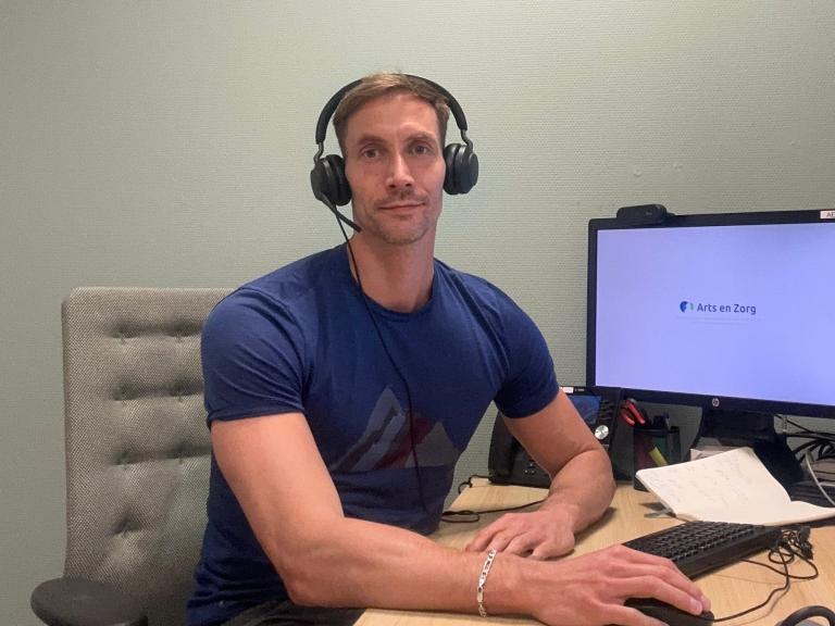 Huisarts Kasper achter de computer met headset